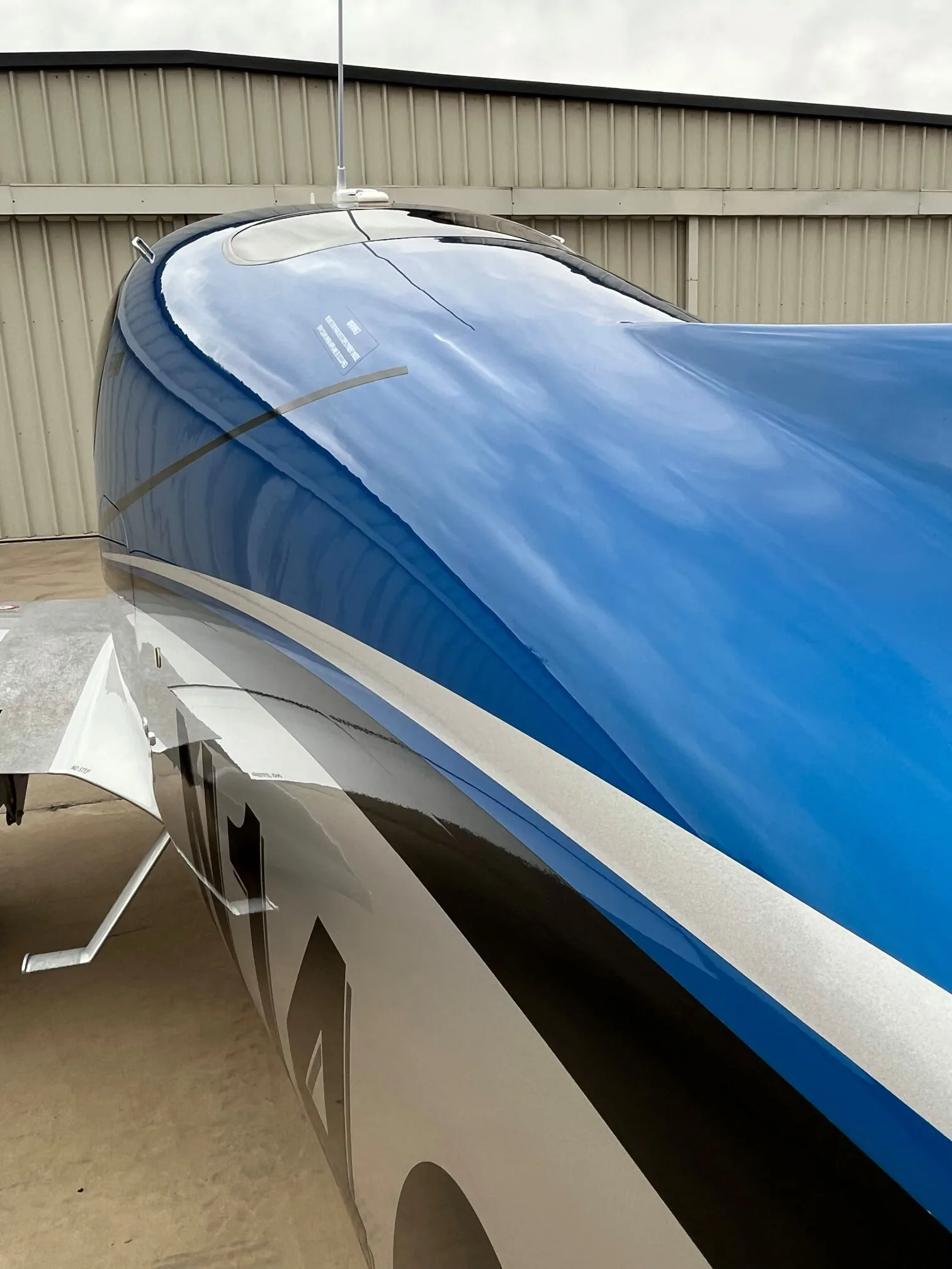 A close-up view of the blue and silver fuselage of the Cirrus SR22 GTS aircraft, showing the paint scheme.