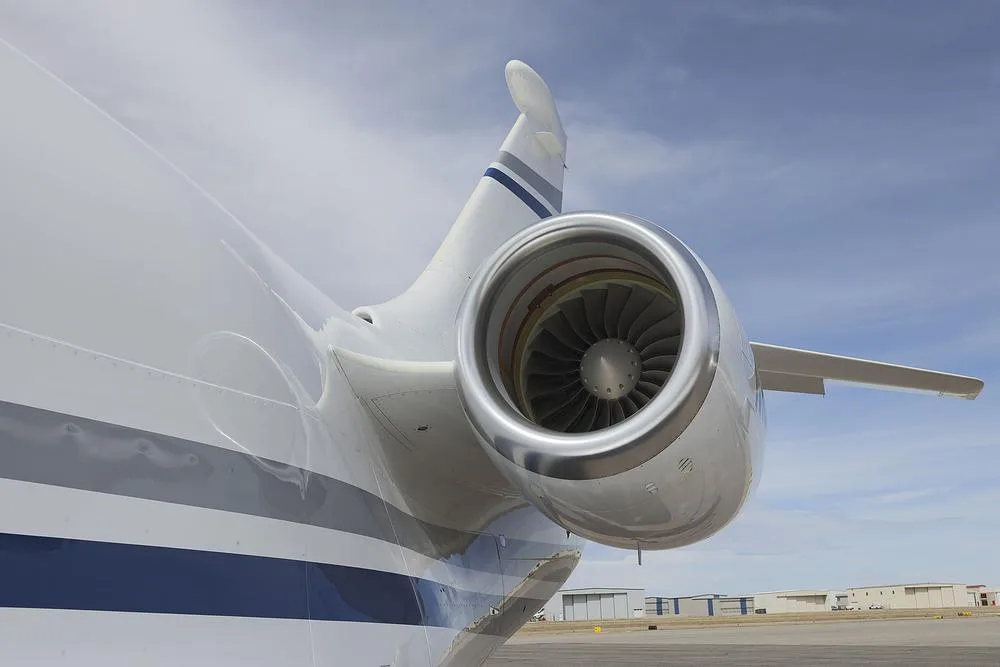A close-up view of the polished engine nacelle and tail section of a white Dassault Falcon 900 business jet.