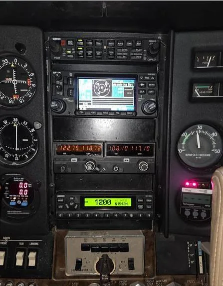 A close-up view of the avionics stack and instruments in the cockpit of a Cessna aircraft, showing N1542M on a display.