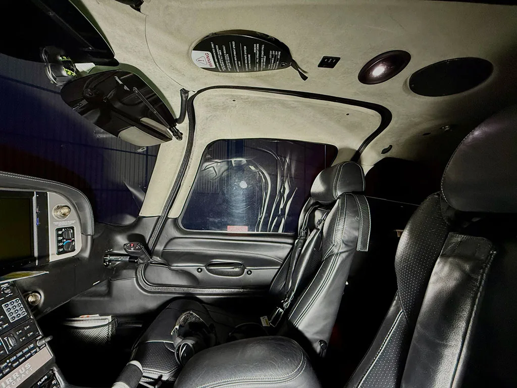The black leather interior of a Cirrus SR22T cabin, showing the pilot and co-pilot seats and part of the dashboard.