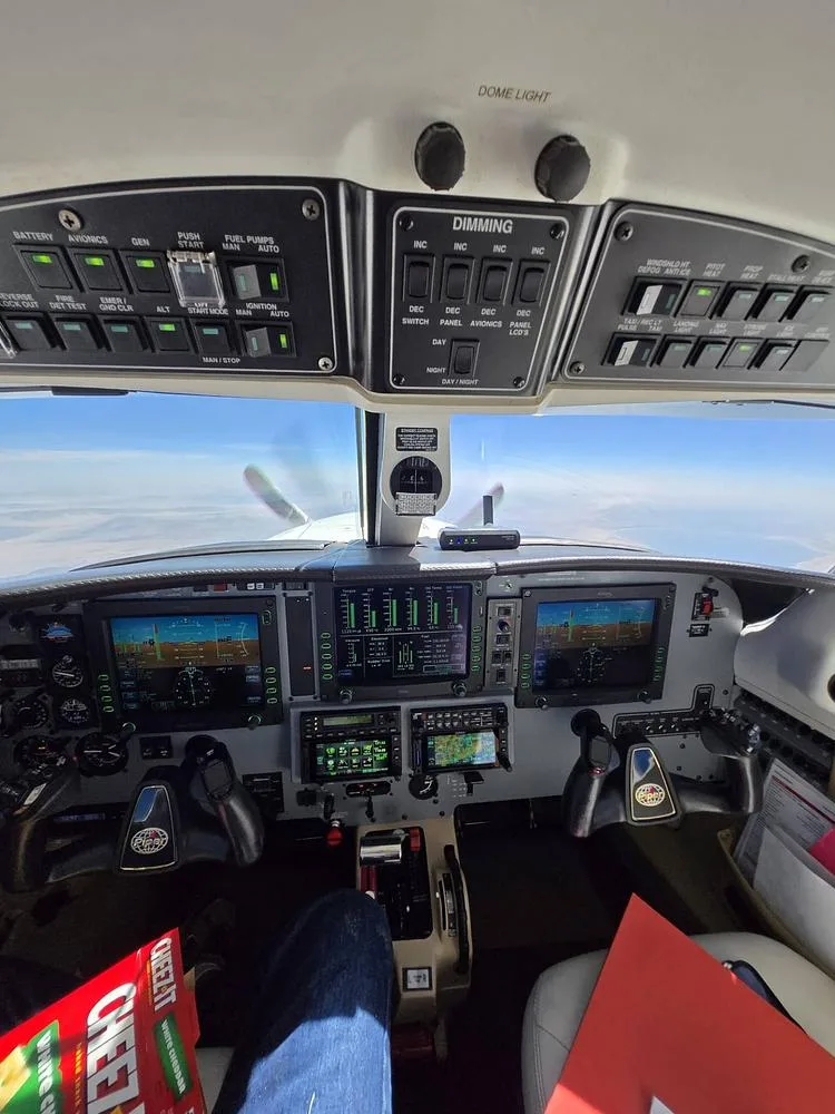 The cockpit of a Piper Meridian aircraft in flight, showing the instrument panel and controls from the pilot's perspective.