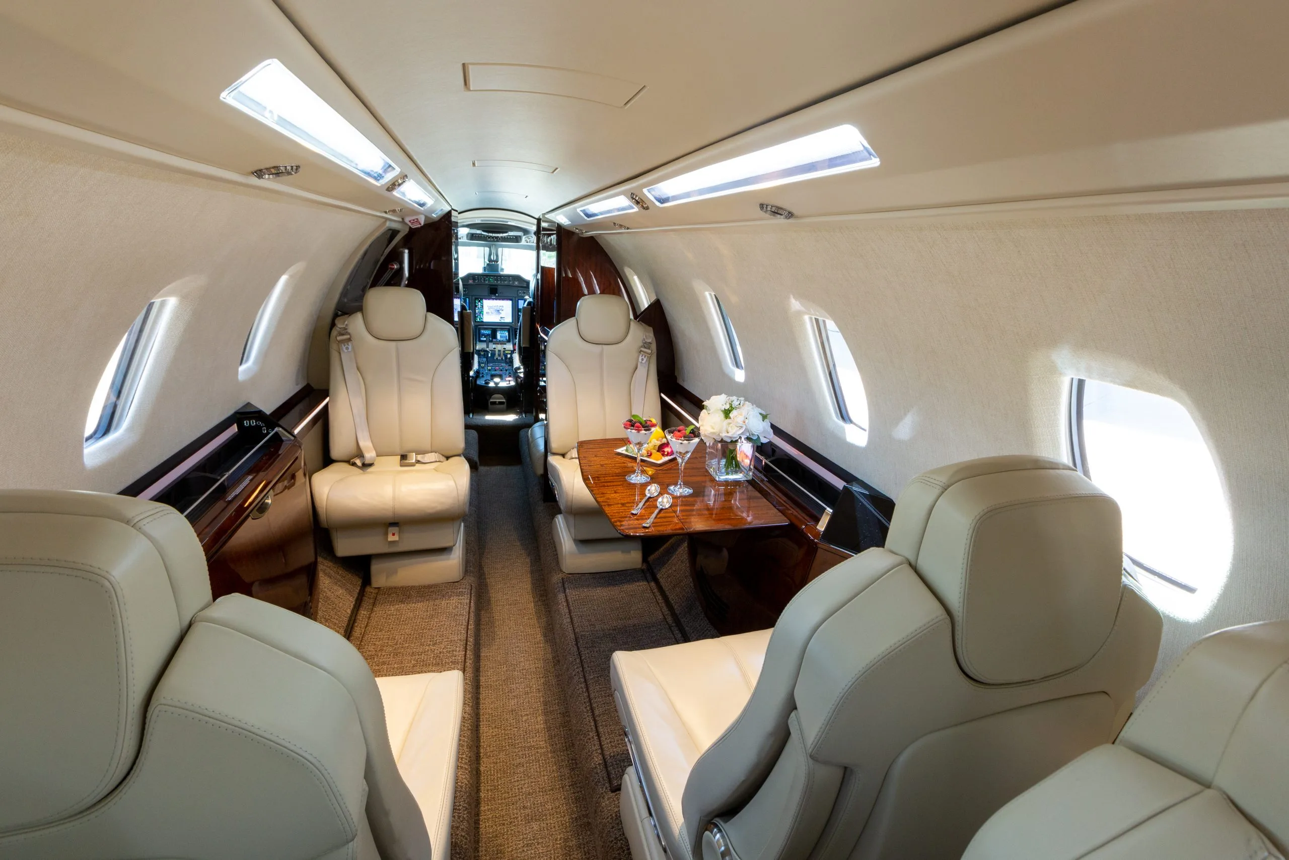 A view of the Citation CJ4 aircraft's interior, showcasing the seating and table.