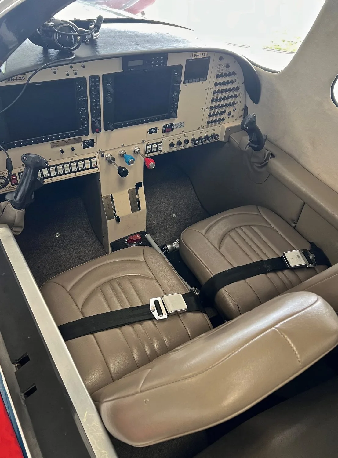 The interior cabin of a Jabiru J430 aircraft (VH-LZS) with two tan leather seats and a view of the instrument panel.