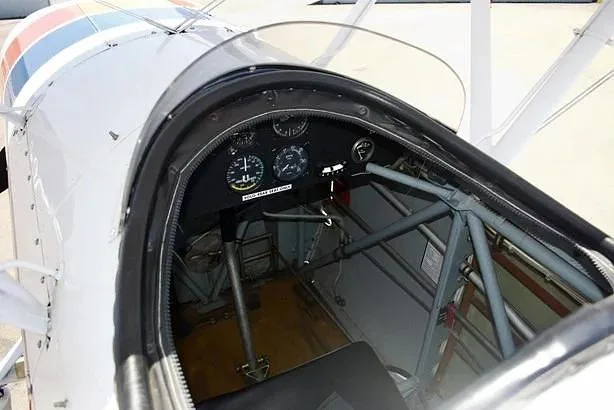 A view into the open cockpit of a biplane, showing the instrument panel and internal structure.