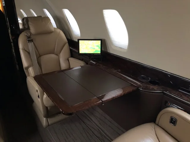 Interior view of the aircraft with leather seats and a table.