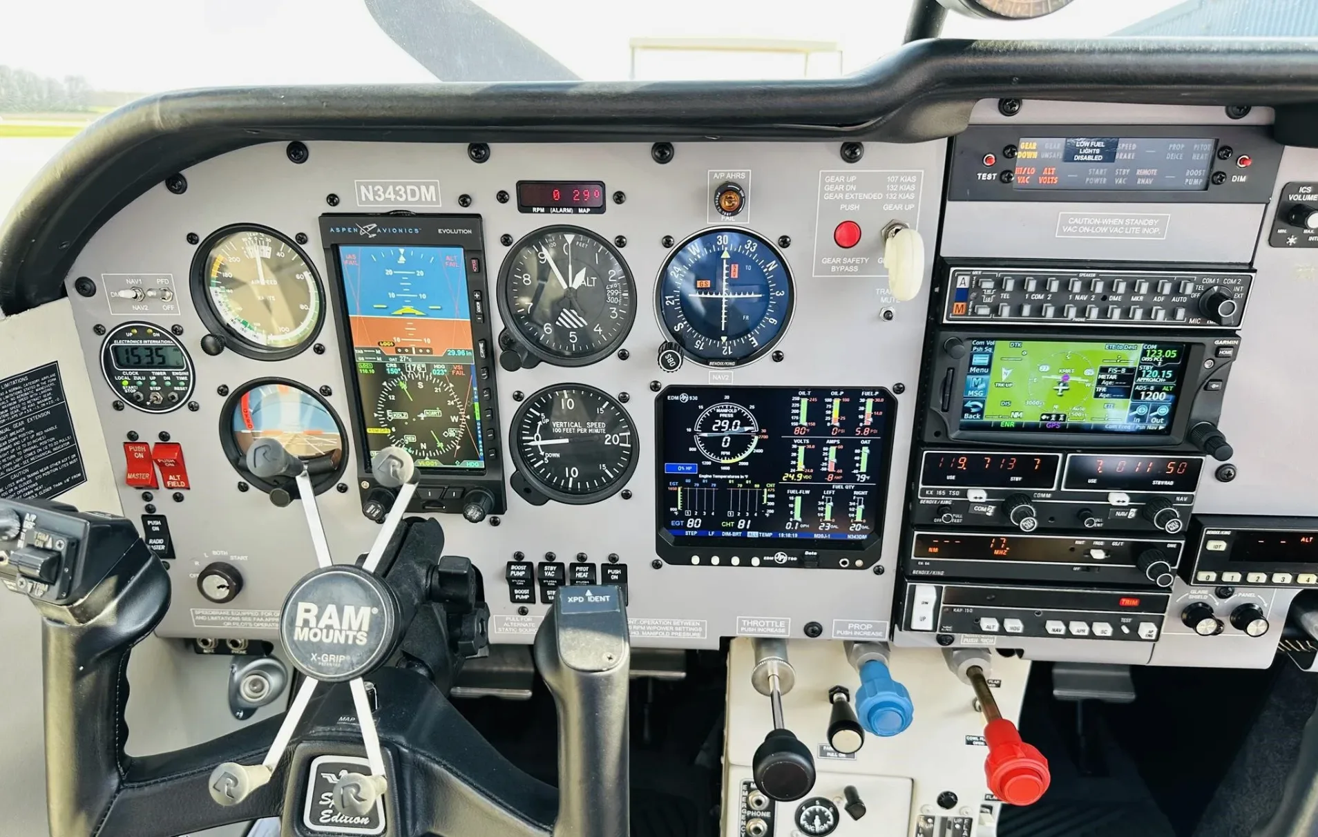 The cockpit of a Mooney aircraft, showing the instrument panel with analog gauges and digital displays.