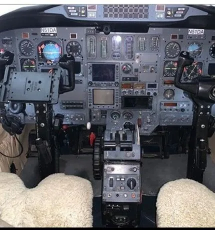 The cockpit instrument panel of the aircraft, showing various gauges, screens, and controls.