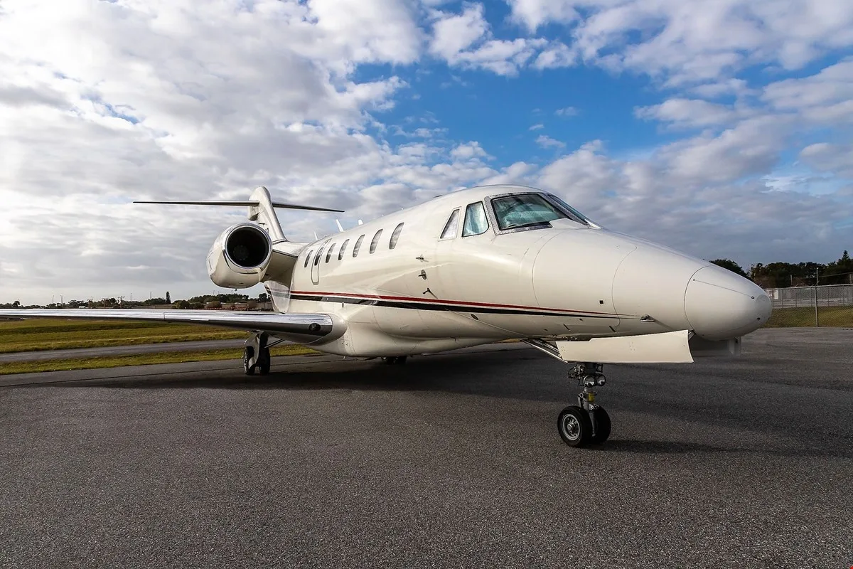 A Citation X aircraft parked on the tarmac under a cloudy sky.