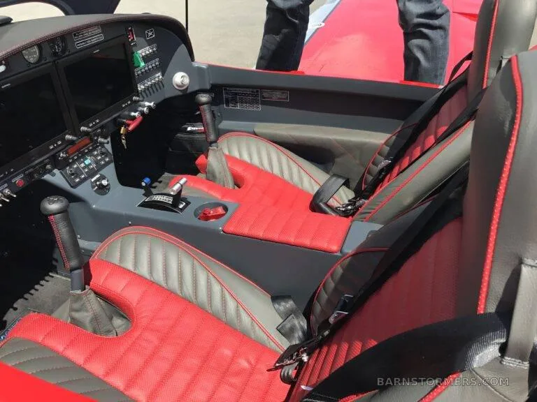 The red and gray leather interior of a Bristell aircraft, showing the seats and center console.