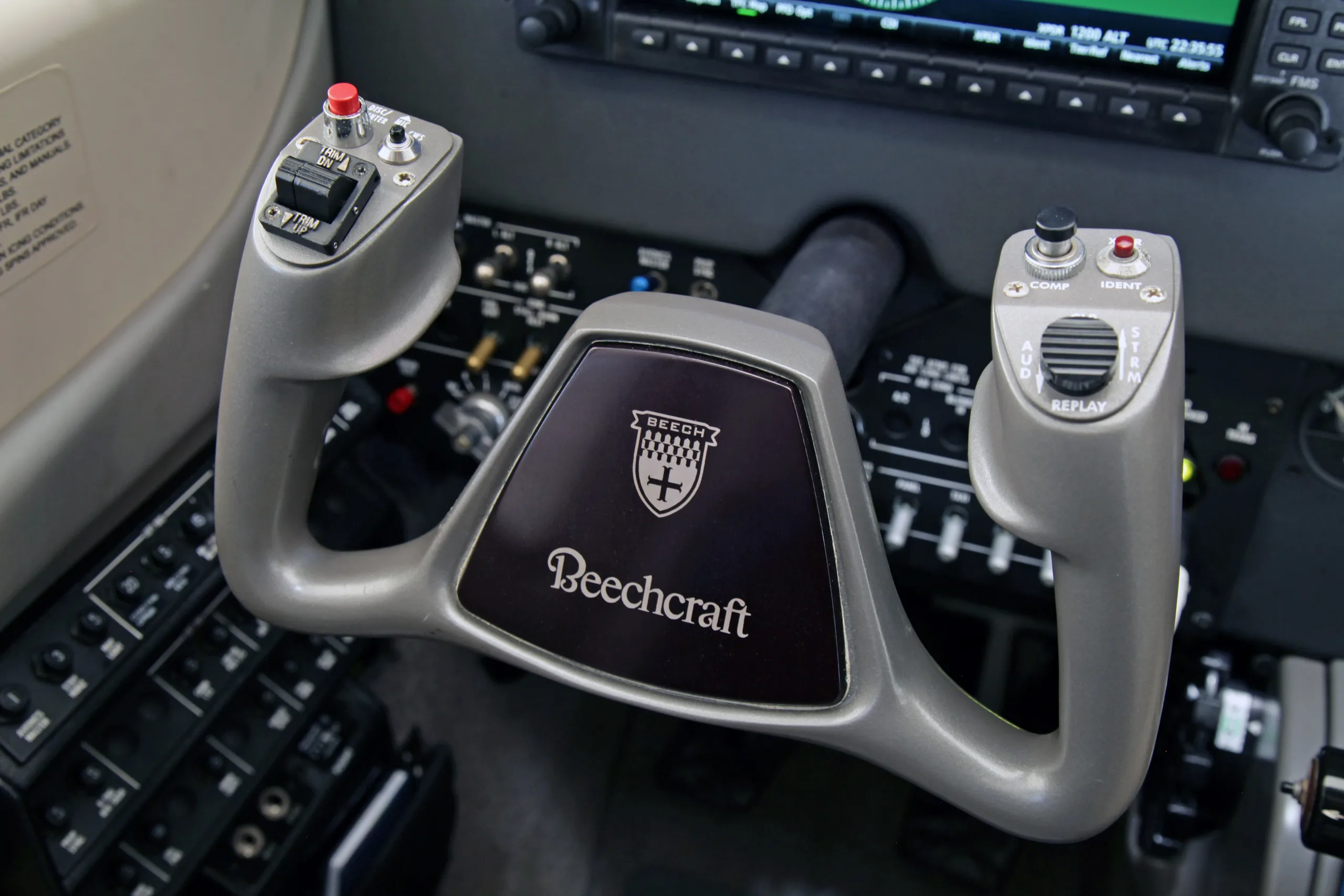 A detailed view of a small aircraft cockpit featuring grey leather seats, dual yokes, and modern Garmin avionics.