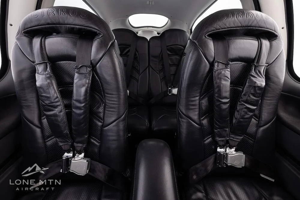 The black leather interior seats of a Cirrus SR22T aircraft, showing the front and rear passenger seats.