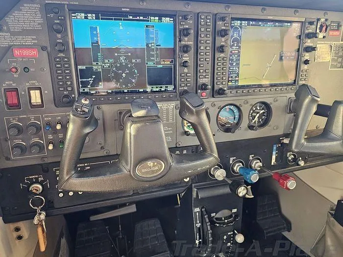 The cockpit features a modern glass panel with two large displays, traditional gauges, and a control yoke.
