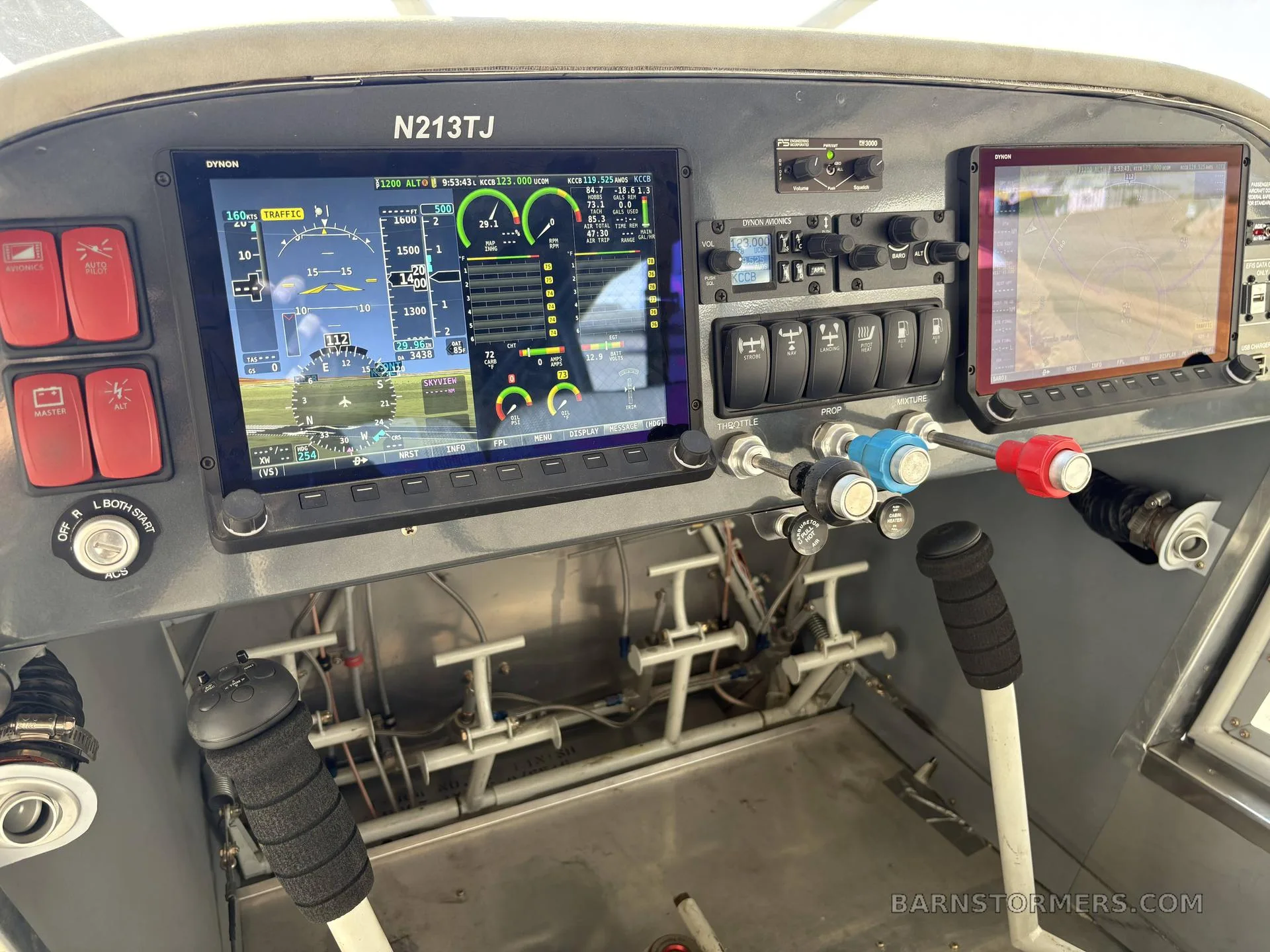 The modern cockpit of an aircraft, featuring two large digital displays showing flight information and a GPS map, along with various controls and switches.